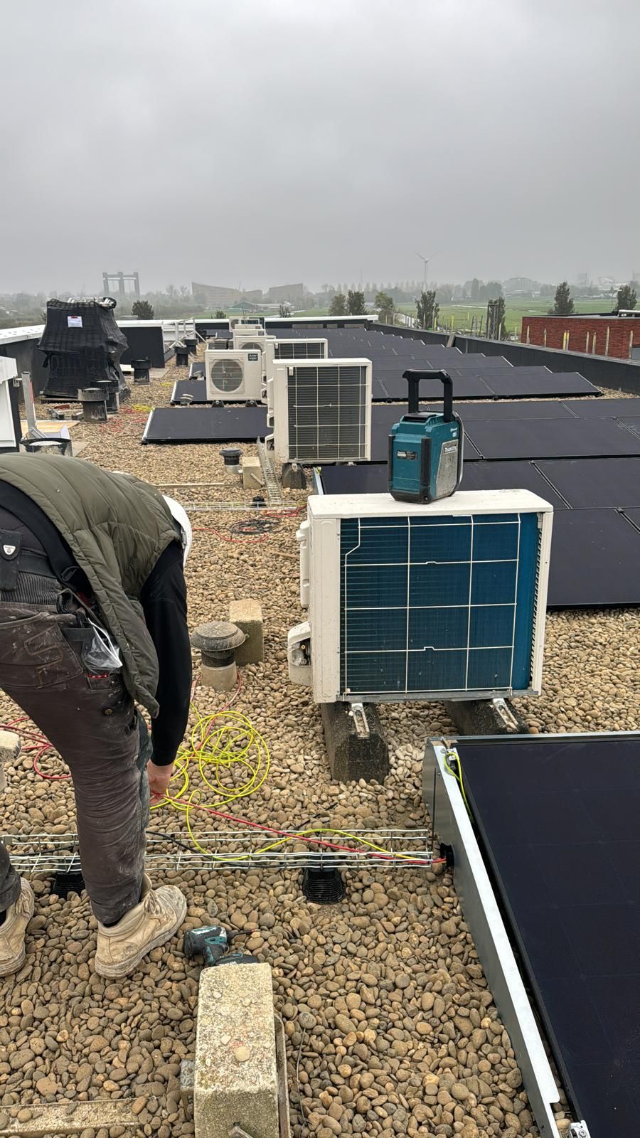 Airco-buitenunits en zonnepanelen op een plat dak