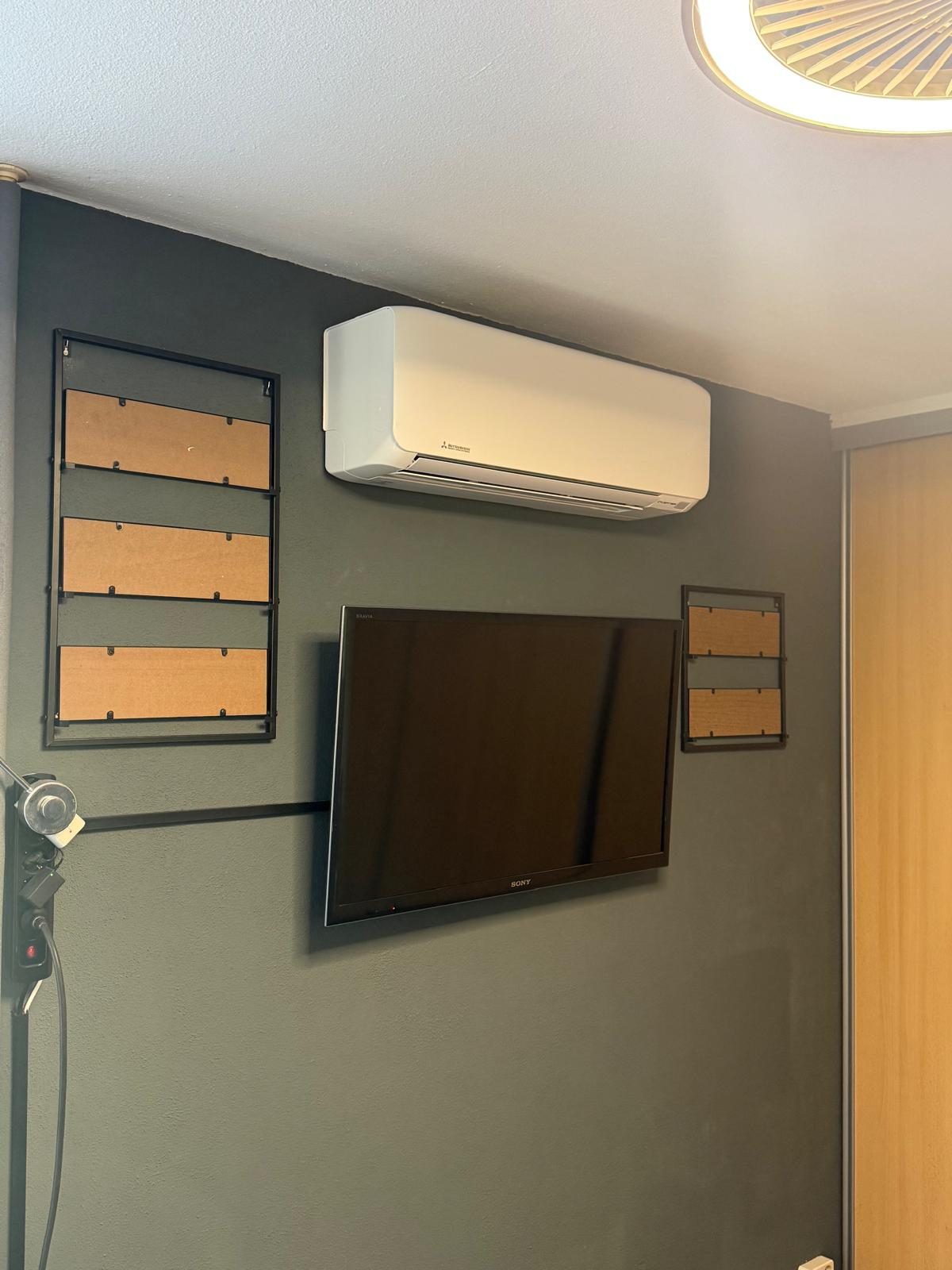 Airco-binnenunit aan een donkere wand in de woonkamer