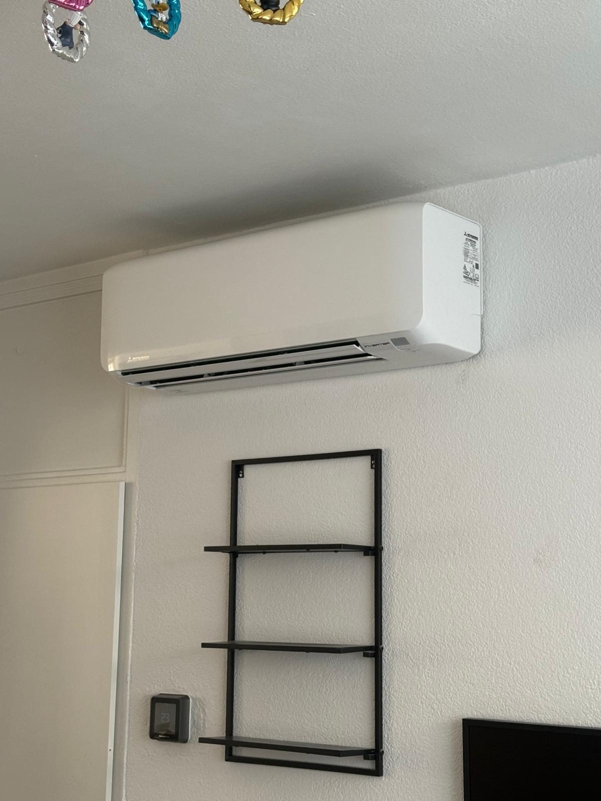 Airco-binnenunit boven een wandrek