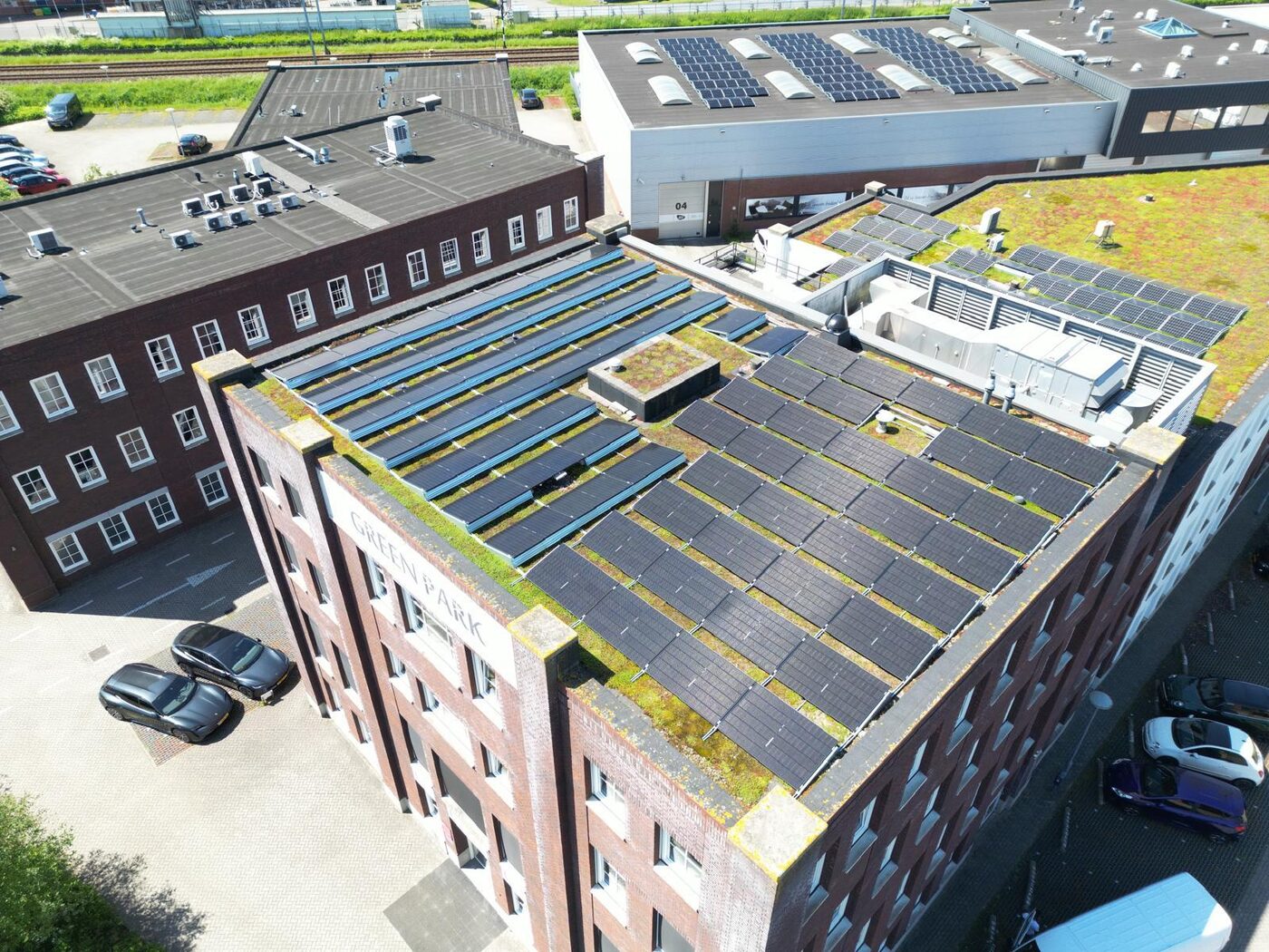 Drone-luchtfoto van zonnepanelen op groendak van een bedrijfspand op een bedrijventerrein