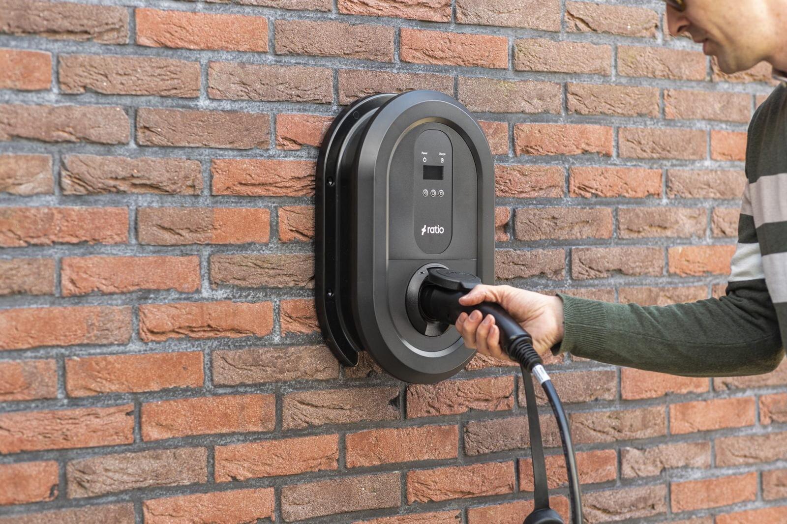 Wandlaadpaal vakkundig gemonteerd aan een bakstenen gevel van een woning, klaar voor gebruik