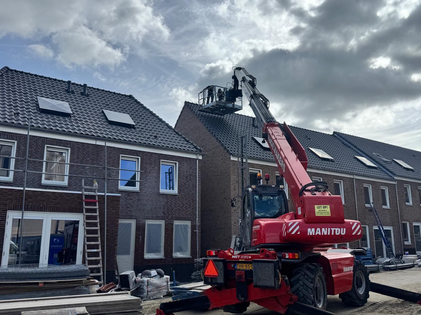 Hoogwerker bij nieuwbouwwoningen voor het plaatsen van zonnepanelen