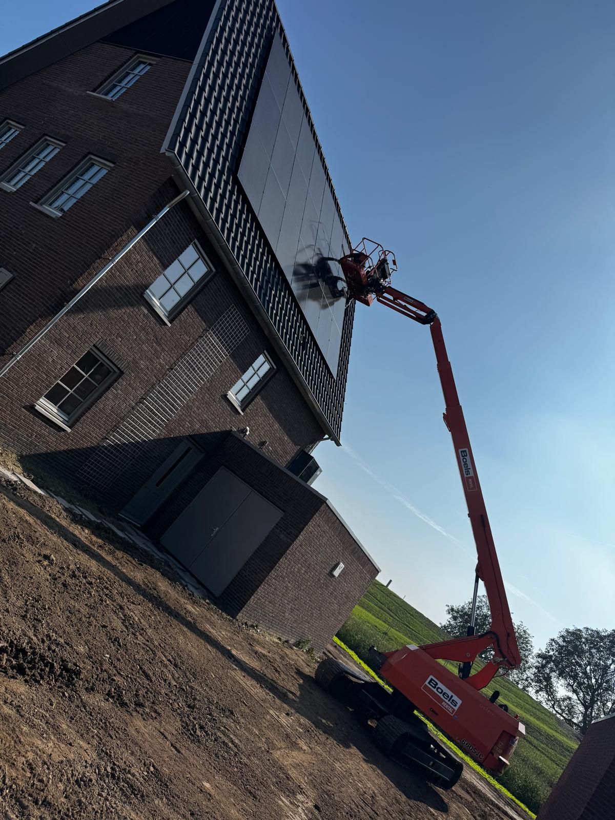 Hoogwerker bij een woning voor het plaatsen van zonnepanelen