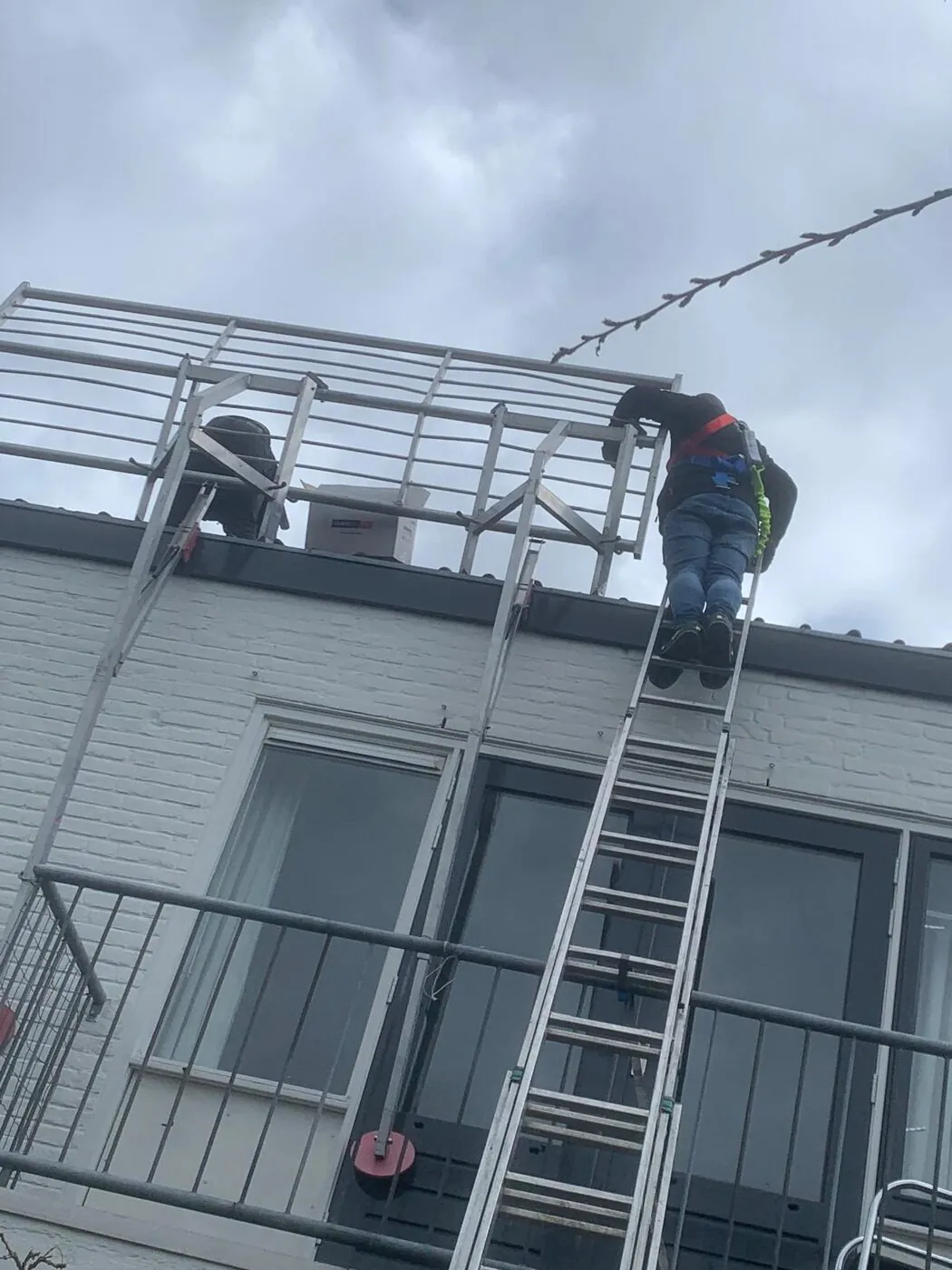 Monteur met valbeveiliging onderweg naar een installatieklus