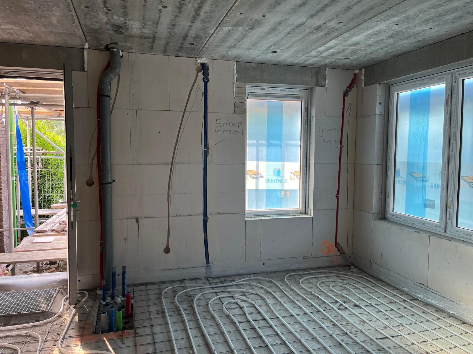 Vloerverwarmingsleidingen en verdeler in een woning in aanbouw