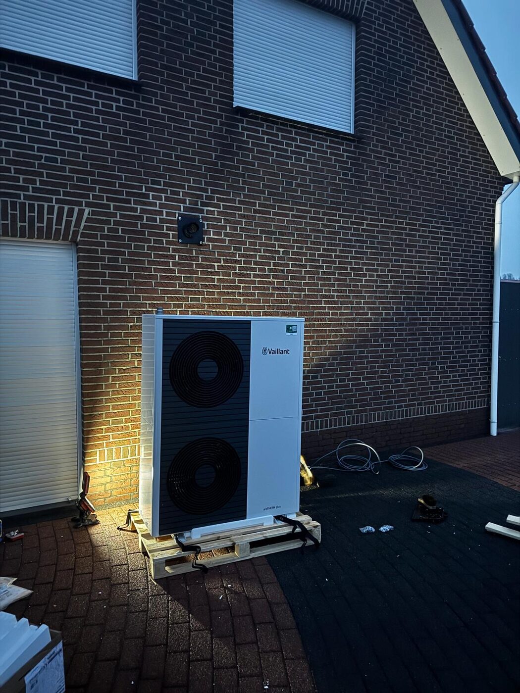 Vaillant lucht-water warmtepomp buitenunit geplaatst tegen bakstenen gevel van woning
