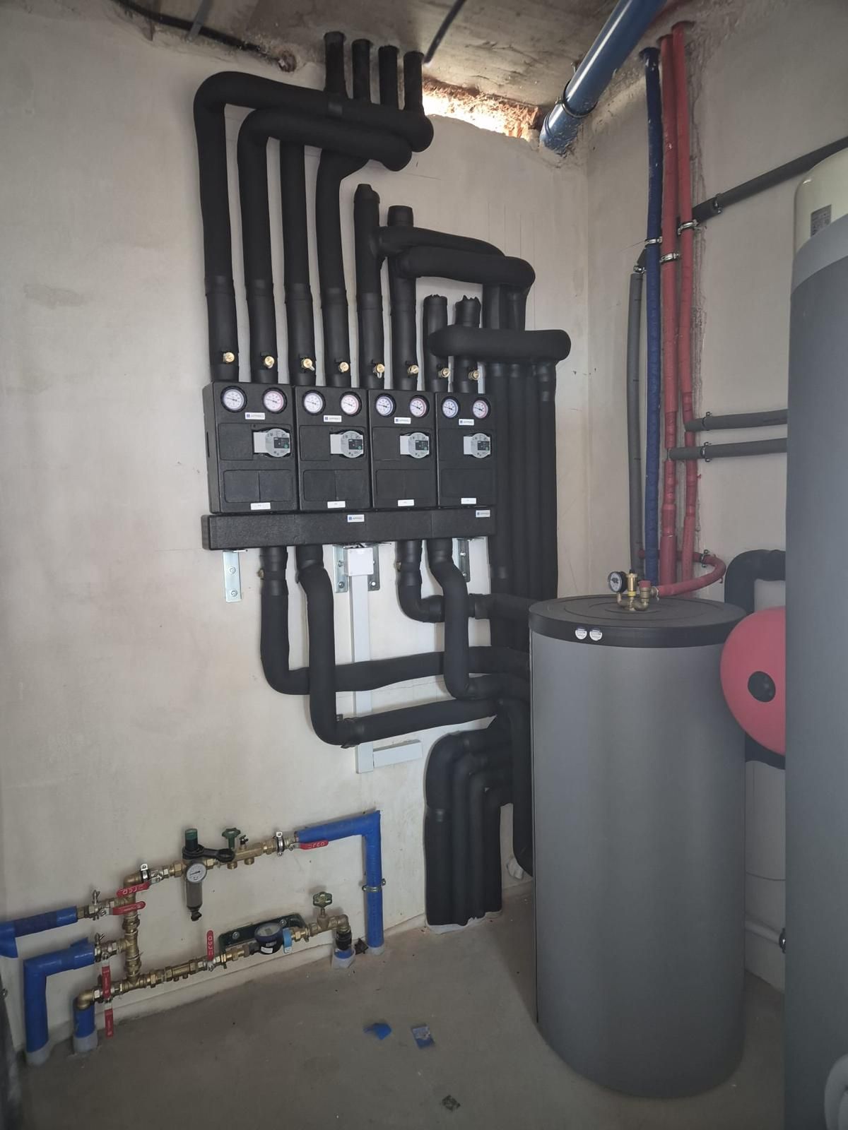Binnenopstelling warmtepomp met leidingwerk en boilervat