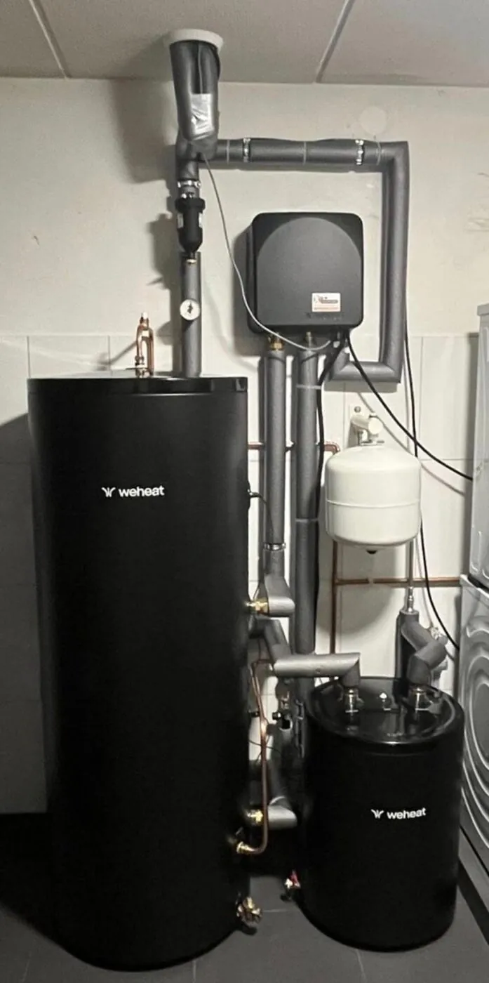Warmtepomp binnenunit met buffervat en leidingwerk in een technische ruimte