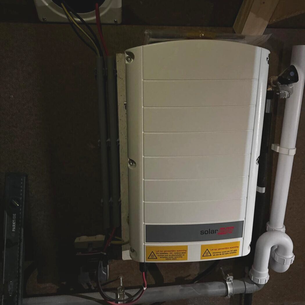SolarEdge omvormer voor zonnepanelen gemonteerd aan wand in technische ruimte