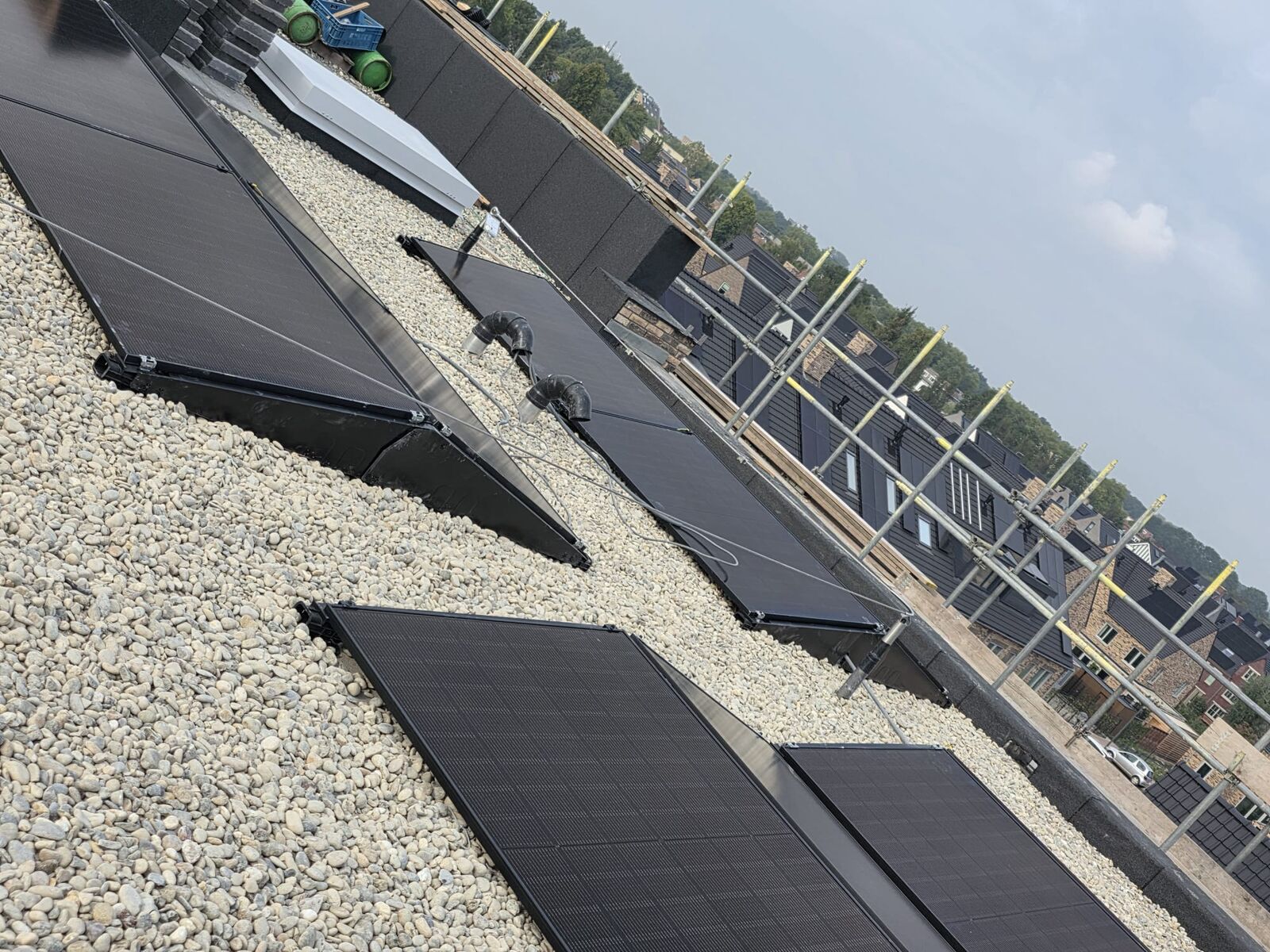 Rijen zonnepanelen op een plat dak met grind
