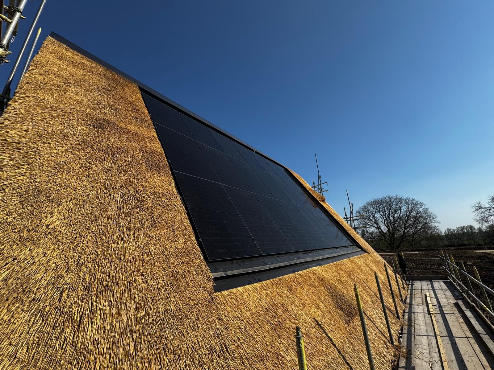 Zonnepanelen geïntegreerd in een rieten dak