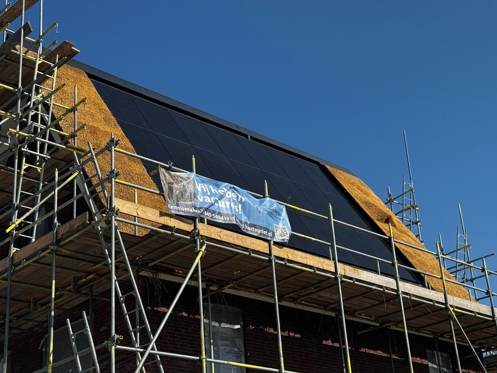 Zonnepanelen in een rieten dak tijdens de bouw