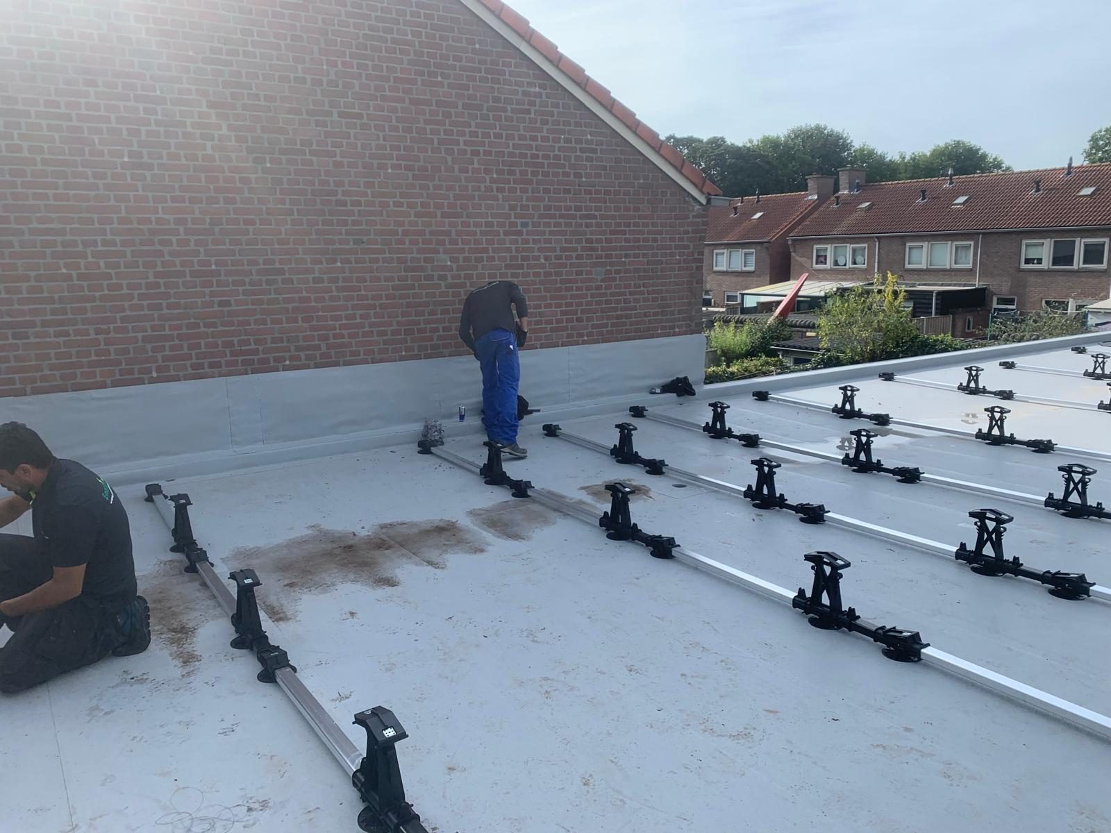 Montage van het onderstel voor zonnepanelen op een plat dak