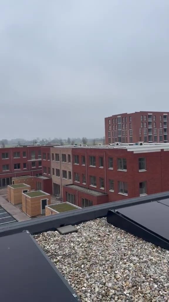Zonnepanelen op het platte dak van een woningcomplex